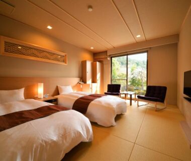 Tatami flooring with twin beds, seating area and garden view at Japanese Ryokan Seryo in Kyoto