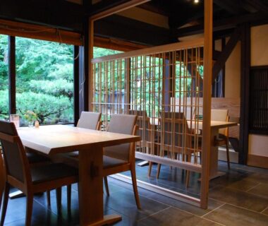 Traditional dining area with wooden table, shoji screens and garden view at Japanese Ryokan Seryo in Kyoto