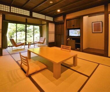 Tatami room with low wooden table, floor chairs, shoji screens and garden view at Japanese Ryokan Seryo in Kyoto