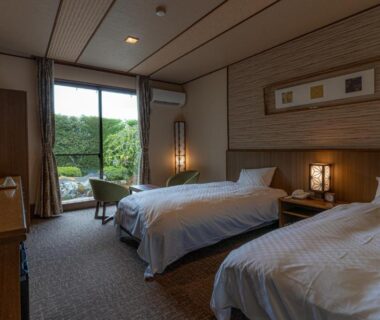 Twin beds with garden view through sliding doors at Japanese Ryokan Seryo in Kyoto