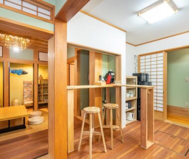 Tatami room with low table, shoji screens, wooden counter and stools at ryokan in Asakusa, Tokyo