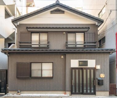 Two-story traditional wooden house exterior with sliding shutters and entrance in Asakusa Tokyo city setting