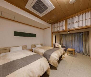 Tatami-floored twin bedroom with low beds, shoji screens and wooden ceiling at Jizaiso, Tochigi