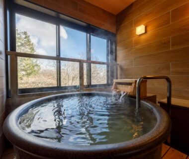 Round ceramic indoor soaking tub with wooden interior and window view at Jizaiso in Tochigi, Kantō, Japan