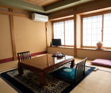 Tatami room with low table, shoji screens and cushions at Jizokan Matsuya Ryokan, Nagano
