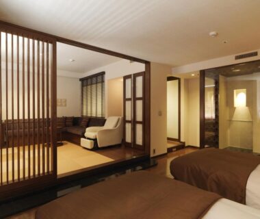 Twin beds and tatami seating with wooden lattice partition at Jozankei Tsuruga Resort Spa Mori no Uta in Hokkaidō