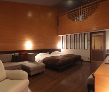 Wood-paneled guest room with beds and sofa at Jozankei Tsuruga Resort Spa Mori no Uta, Hokkaidō
