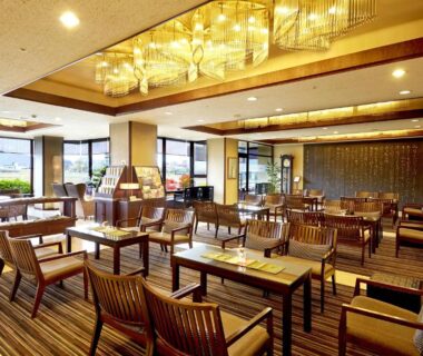 Bright ryokan lounge with wooden chairs, low tables and large windows at Juhachiro in Gifu