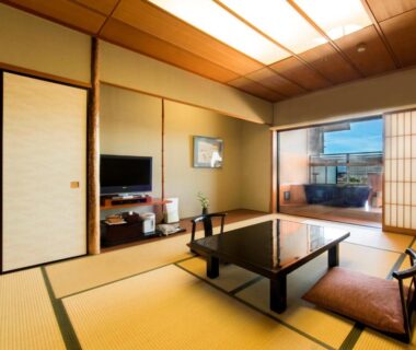 Traditional tatami room with low table, zabuton cushions, shoji screens and sliding doors at Juhachiro in Gifu