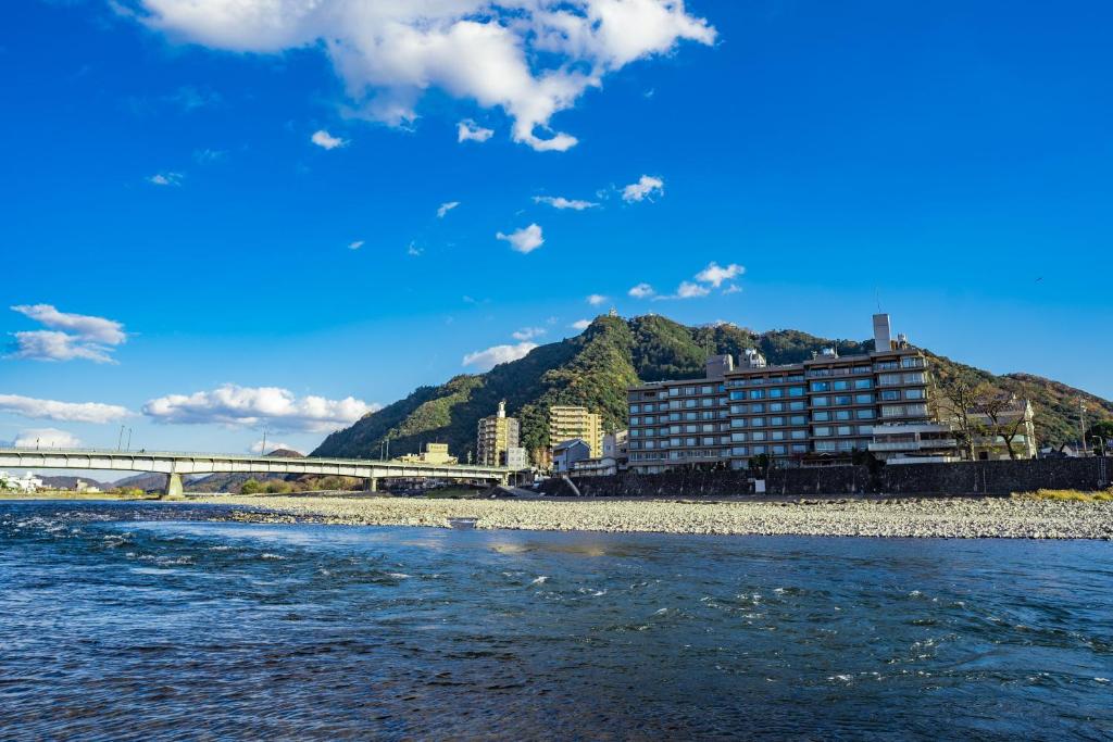 Riverside exterior Juhachiro Gifu Japan Multi-story ryokan along a riverside with bridge and mountain backdrop in Gifu, Chūbu, Japan