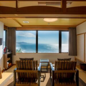 Tatami seating area facing a large window with coastal view at Jukaitei in Kyoto, Kansai