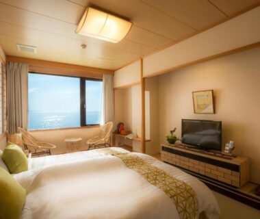 Western-style room with two beds, seating area and bathtub by window at Jukaitei, Kyoto Kansai