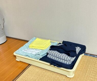 Tray with folded yukata and towels on tatami mat at Juvankan, Nagano