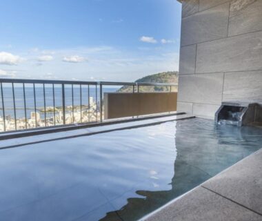 Outdoor onsen bath on balcony at KAMENOI HOTEL Atami with coastal Shizuoka view