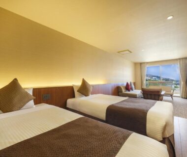 Twin-bedded room with balcony and seating at KAMENOI HOTEL Atami, Shizuoka