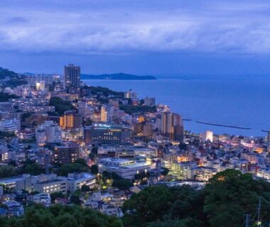 Dusk coastal cityscape with bay and illuminated buildings in Atami, Shizuoka
