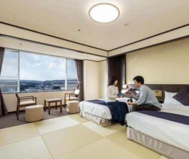 Couple seated on twin beds in tatami room at KAMENOI HOTEL Ichinoseki, Iwate Tōhoku