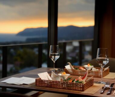 Table with wine glasses and food baskets by window at KAMENOI HOTEL Izukogen Shizuoka