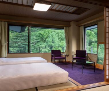Tatami room with twin beds, shoji screens and seating by windows at KAMENOI HOTEL Nikko Yunishigawa, Tochigi