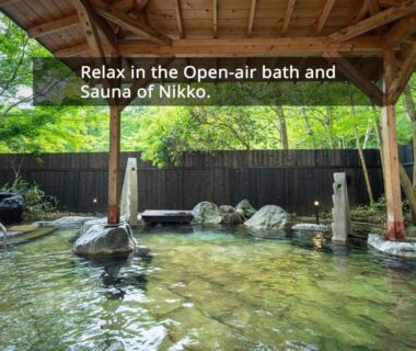 Covered open-air onsen bath with wooden roof, stone seating and green foliage at KAMENOI HOTEL Nikko, Tochigi