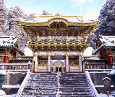 Ornate snow covered temple gate with stone steps and cedar trees, KAMENOI HOTEL Okunikko Tochigi Japan