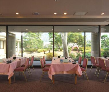 Dining area with pink tablecloths facing manicured garden at KKR Numazu Hamayu, Shizuoka