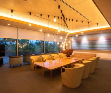 Spacious lounge with low table and upholstered chairs at KKR Numazu Hamayu in Shizuoka, Chūbu, Japan