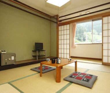 Tatami room with low table, cushions and shoji screens at Kadoya Shinkan in Hyōgo, Kansai