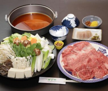 Pot of broth with platter of thinly sliced beef and assorted vegetables for hot pot at Kadoya Shinkan, Hyōgo