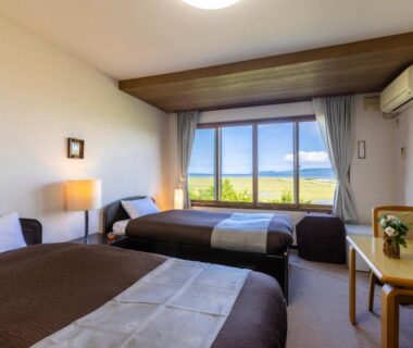 Two single beds with sea view through large window at Kagariya Hokkaido