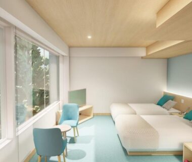 Twin beds and seating by window overlooking greenery at Kagetsuen, Kanagawa, Japan