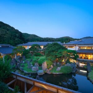 Lit garden pond and traditional buildings at Kagetsutei with mountain backdrop in Shizuoka Chūbu