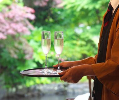 Two flutes on a tray held by a server at Kagetsutei ryokan, Shizuoka, Chūbu, Japan