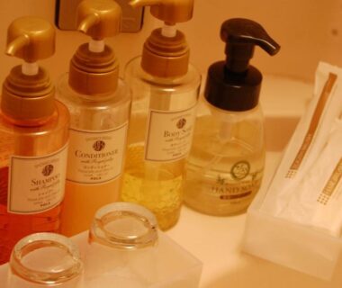 Shampoo and body wash dispensers, toothbrush packets and glass tumblers on ryokan bathroom counter at Kaigetsu, Mie