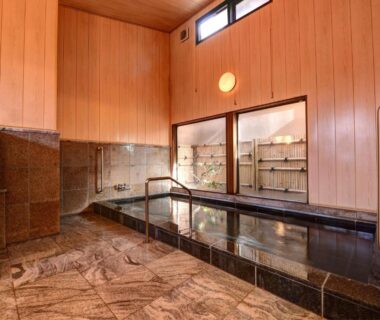 Spacious tiled indoor bath with wooden walls at Kaihinsou Kamakura in Kanagawa