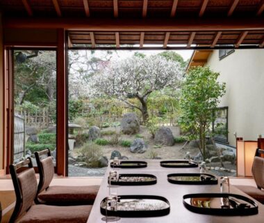 Tatami dining area with low lacquer tables and cushions overlooking a stone garden at Kaihinsou Kamakura in Kanagawa