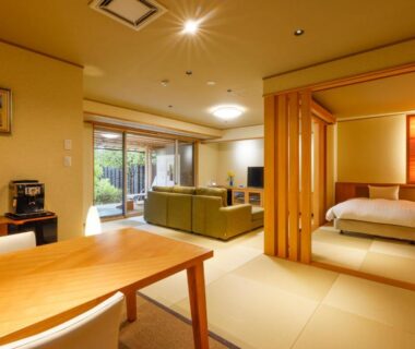 Tatami room with futon, sofa and shoji partitions at Kaikatei Hanagozen in Kyoto, Kansai