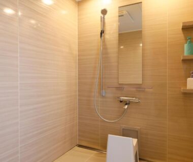 Tiled shower stall with handheld shower, mirror, stool and toiletries at Kaikatei Hanagozen in Kyoto