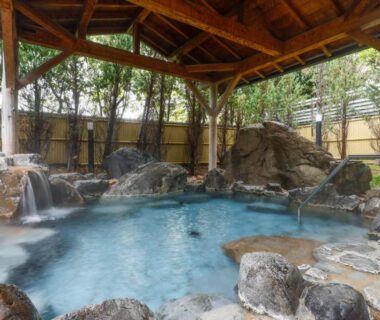 Stone-lined outdoor hot spring bath with wooden shelter and bamboo fence at Kaikatei Hanagozen, Kyoto, Kansai