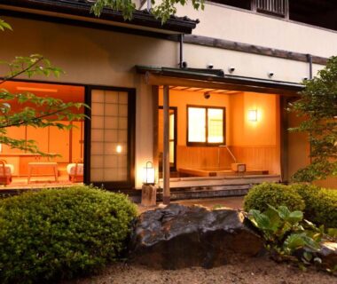 Exterior entrance with lit shoji rooms, tatami interior visible and manicured courtyard garden at Kaikatei Hanagozen in Kyoto