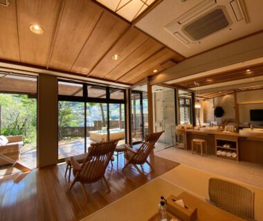 Tatami seating area with wooden lounge chairs and garden view at Kaiseki Ryokan Ashikari in Kanagawa Japan
