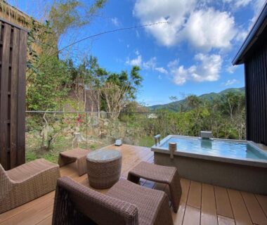 Outdoor bath on wooden deck with wicker seating and mountain view at Kaiseki Ryokan Ashikari Kanagawa