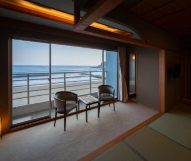 Tatami seating area with chairs and balcony overlooking the sea at Kaiyutei in Shizuoka coastal setting