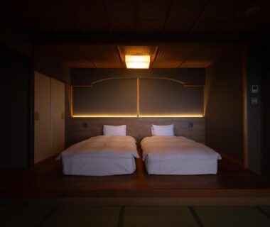 Tatami room with two low beds, shoji screens and subdued lighting at Kaiyutei in Shizuoka