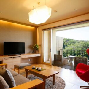 Sofa and red armchair by balcony with TV and greenery view at Kakimotoya, Nara