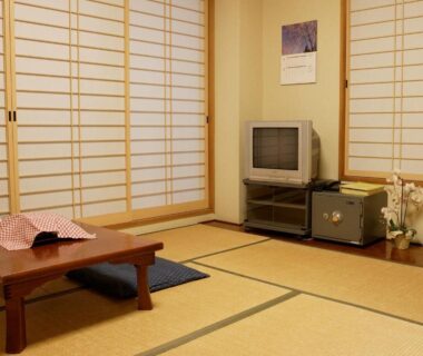 Tatami room with low table, zabuton cushions and shoji screens at Kakiya Ryokan in Kanagawa, Japan