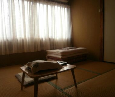 Traditional tatami room with low table and folded futon at Kakiya Ryokan in Kanagawa