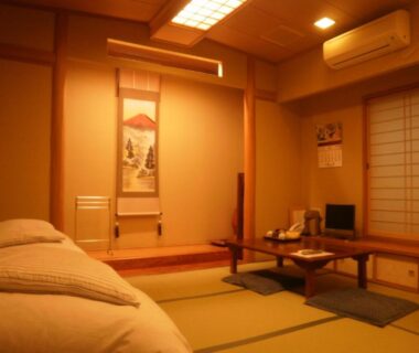 Japanese tatami room with low beds, tokonoma alcove, shoji screen, low table and floor cushions