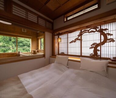 Japanese room with futon bedding, shoji screens, carved wooden panel and garden view at Kakureisen in Saga