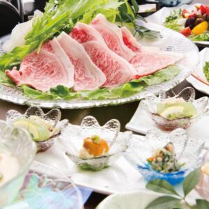 Assorted small dishes and thinly sliced meat served on a table at Kakureisen ryokan in Saga, Kyushu, Japan